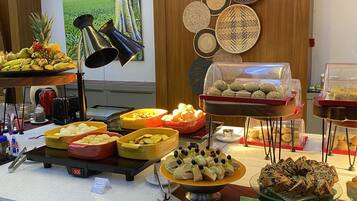A buffet setup with various food items and a clock displaying 9:06.