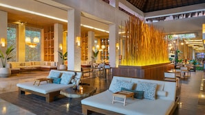 A spacious lobby with a reception desk, seating areas, and a decorative wall feature.