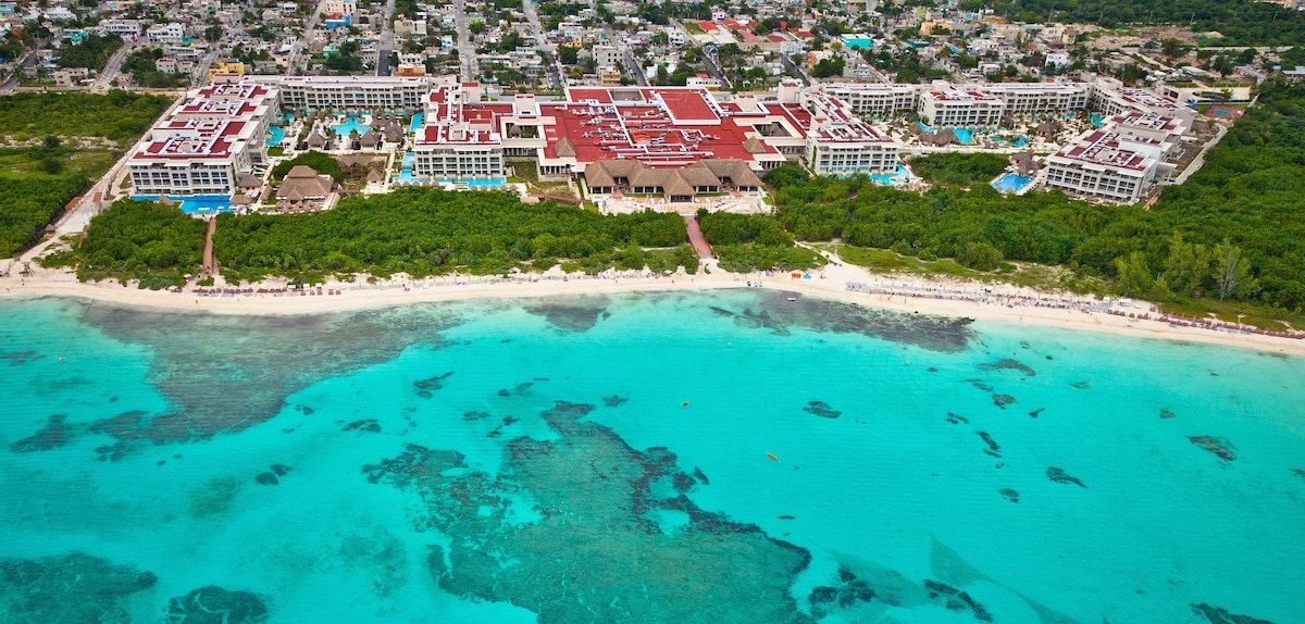 An aerial view of a coastal hotel complex with multiple buildings, a beach, and clear turquoise waters. - Paradisus La Perla - Adults Only - Riviera Maya - All Inclusive (Playa del Carmen)