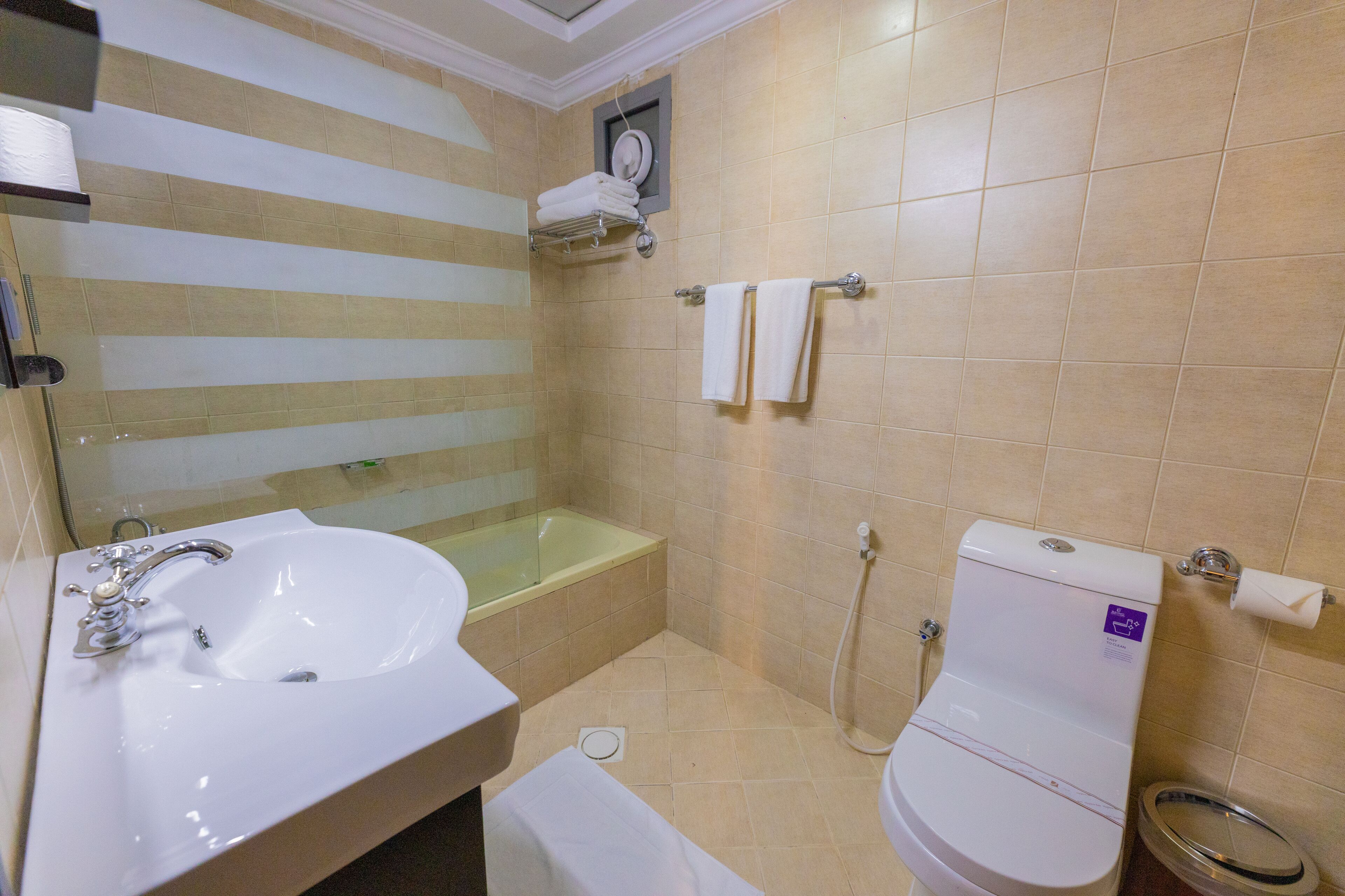 Un baño con lavabo, bañera, inodoro y perchero para toallas.