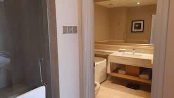 A bathroom with a toilet, sink, and mirror.