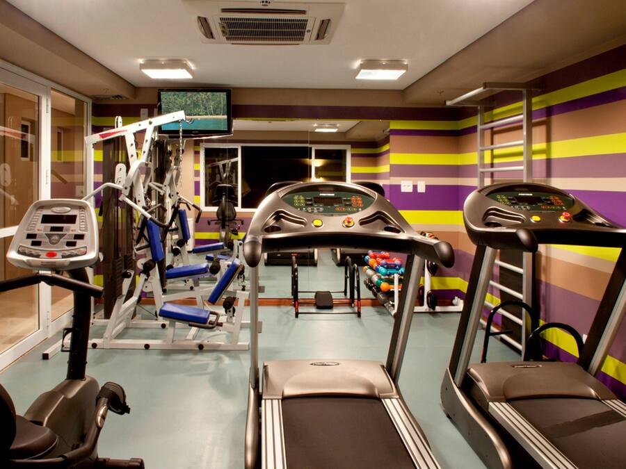 A gym with treadmills, exercise bikes, and weight machines.