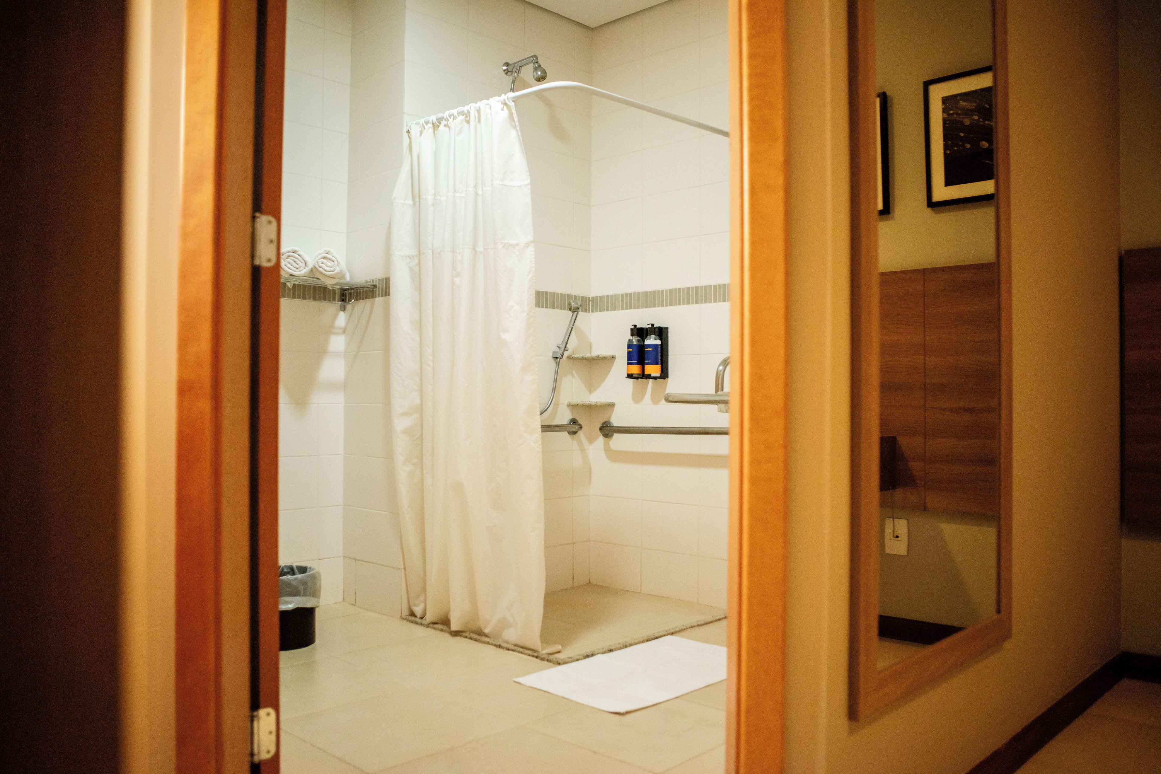 Ein Badezimmer mit Dusche, Waschbecken und Spiegel.