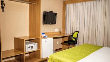 Relax in this stylish room featuring a comfortable bed, desk, and TV.