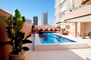 A rooftop pool with lounge chairs and a potted plant. - Comfort Hotel Sertãozinho (Sertaozinho)