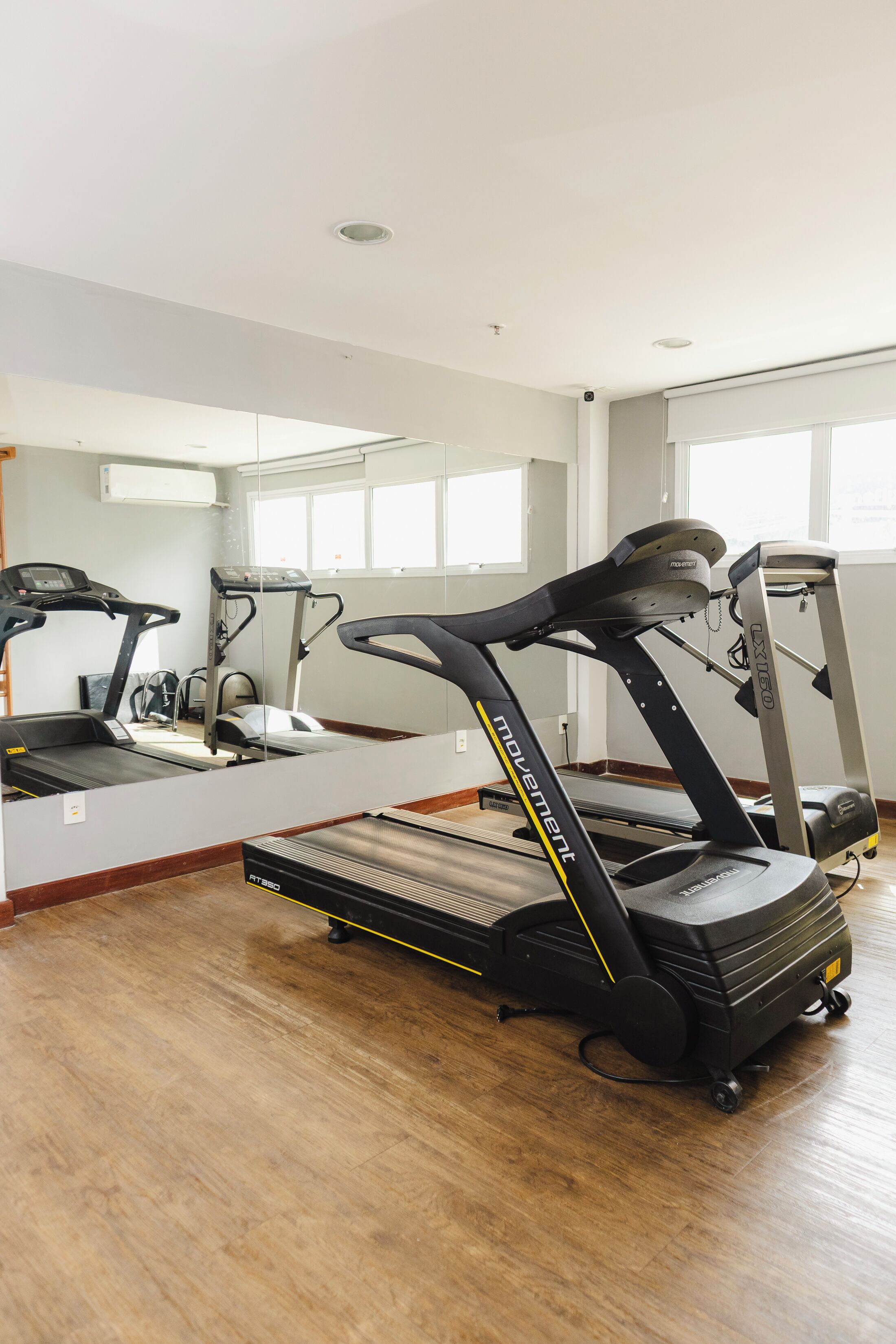 Ein Fitnessstudio mit Laufbändern, einem Ergometer und einem Rudergerät.