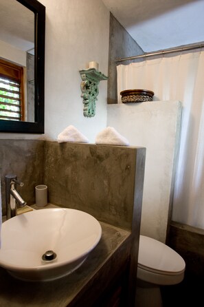 A bathroom with a sink, toilet, and shower curtain. - Villas Sur Mer (Negril)