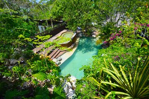 A lush garden with a swimming pool, surrounded by dense foliage and tropical plants. - Villas Sur Mer (Negril)