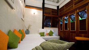 Ein Hotelzimmer mit einem Bett, Kissen, einer Vase, Holzhörnern und einer Bank.