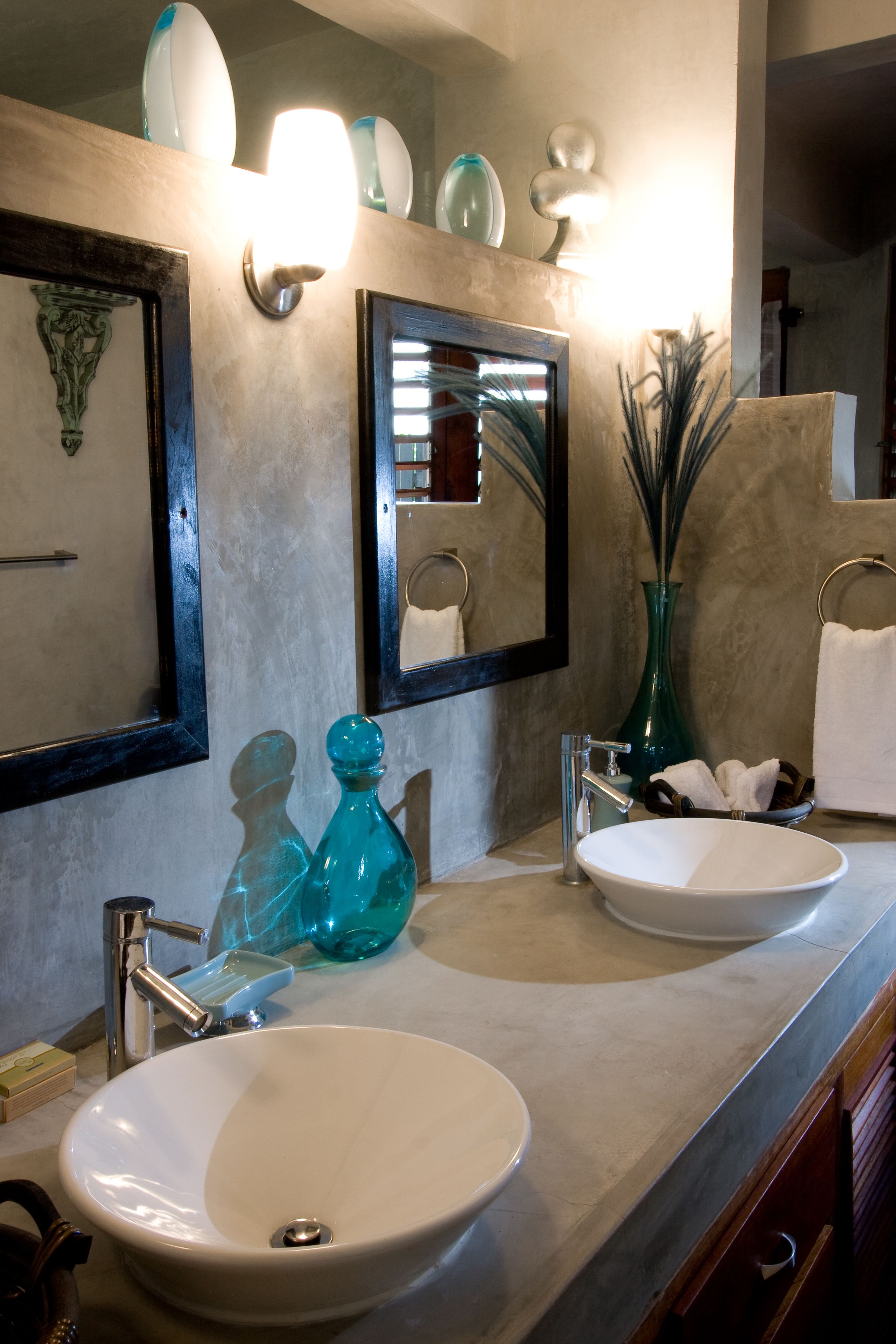 A bathroom with two sinks, a mirror, and decorative items.