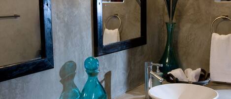A bathroom with two sinks, a mirror, and decorative items.