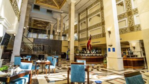 A spacious lobby with a high ceiling, ornate wall decorations, a central bar area, and multiple seating arrangements. - DoubleTree by Hilton Hotel Dhahran (Al Khobar)