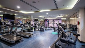 A gym with treadmills, exercise bikes, and weight machines. - DoubleTree by Hilton Hotel Dhahran (Al Khobar)