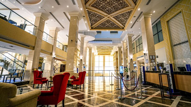 A spacious lobby with high ceilings, ornate ceiling design, and a checkered floor pattern. - DoubleTree by Hilton Hotel Dhahran (Al Khobar)