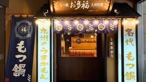 Ein traditionelles japanisches Haus mit Schild und beleuchteten Bannern.