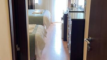 Une chambre d’hôtel avec un plancher en bois, un lit, un bureau et une chaise.