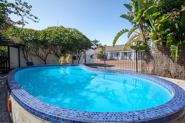 Alberca al aire libre y camastros