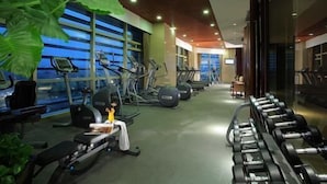 Ein Fitnessstudio mit Laufbändern, Crosstrainern und Kurzhanteln.