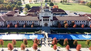 A large building with a central courtyard, a fountain, and a symmetrical garden layout.