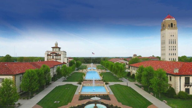 A large building with a central courtyard, a fountain, and a flagpole.