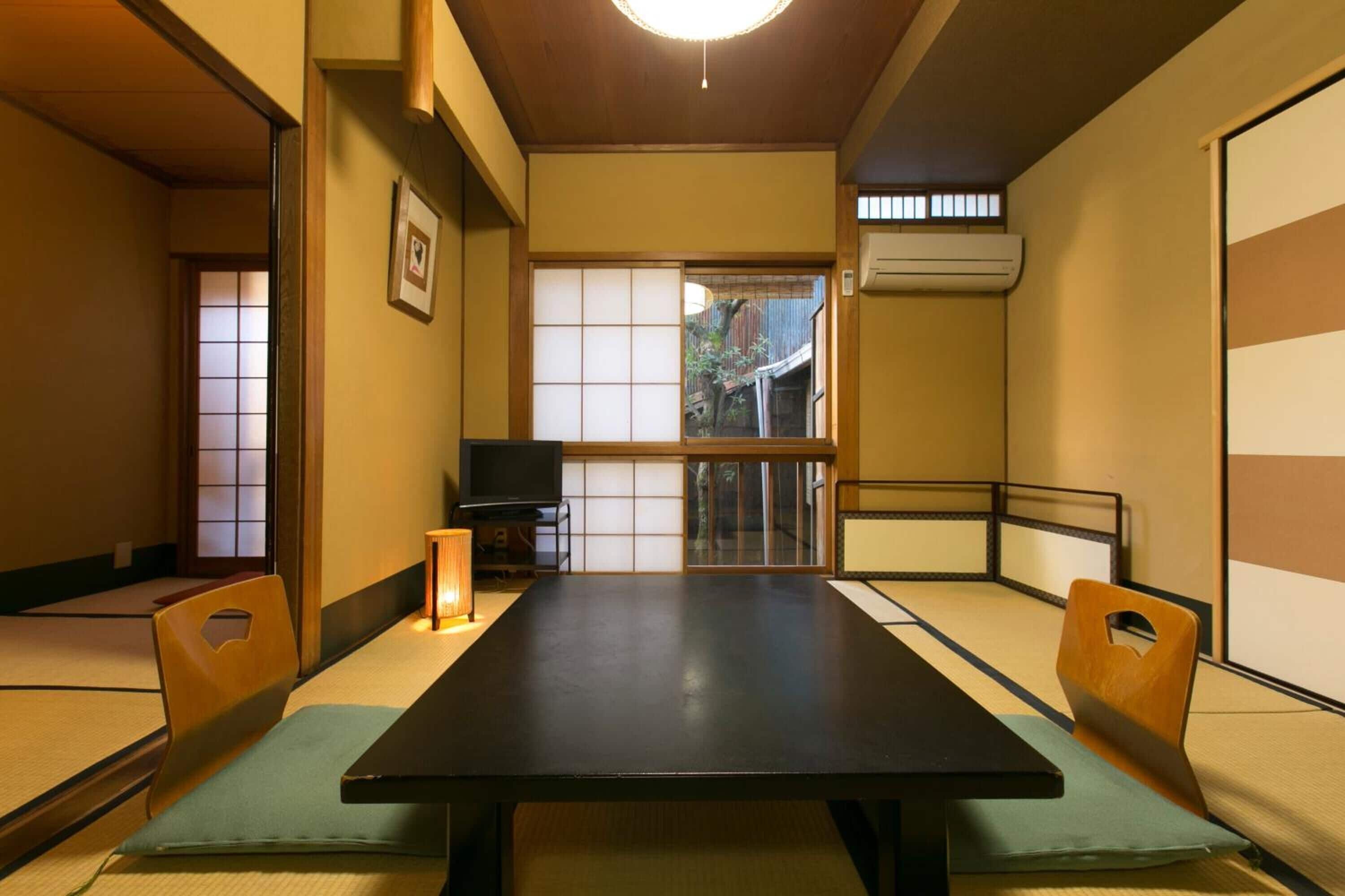 Et traditionelt japansk rum med tatamimåtter, et lavt bord og puder.