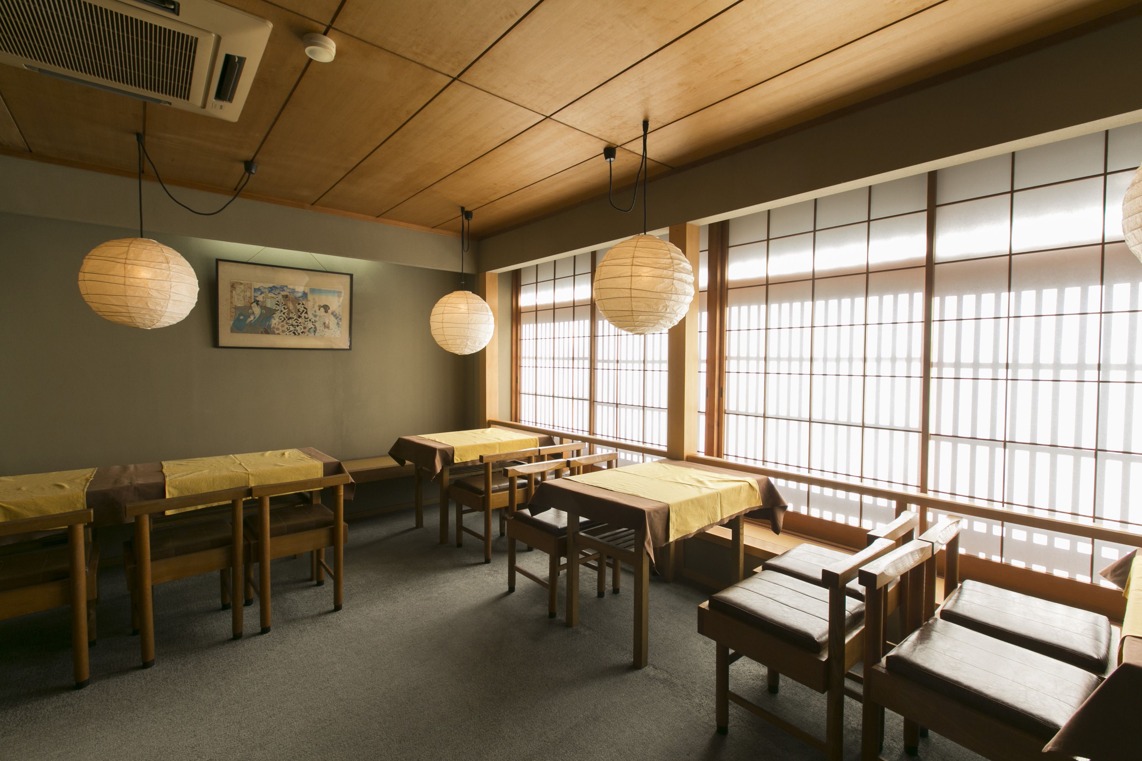 A traditional Japanese-style room with tatami mats, low tables, and sliding doors.
