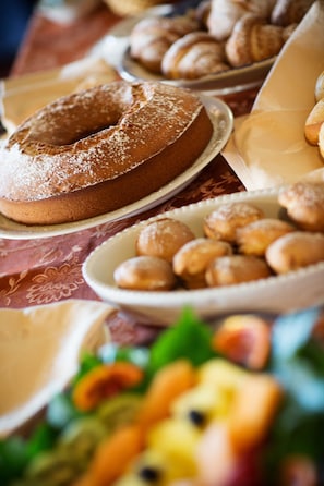 A table with various baked goods including a bundt cake, pastries, and doughnuts. - A Nuciara Park Hotel & Wellness Center (Furci Siculo)