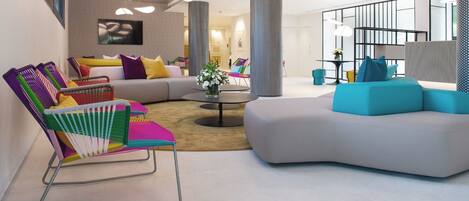 Una sala de estar moderna con un sofá modular, sillas coloridas y una mesa de centro.