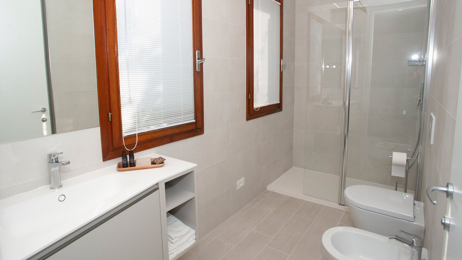 A modern bathroom with a shower, toilet, and vanity.