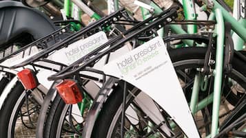 A bicycle with a white sign that reads "hotel president" and "lignano".