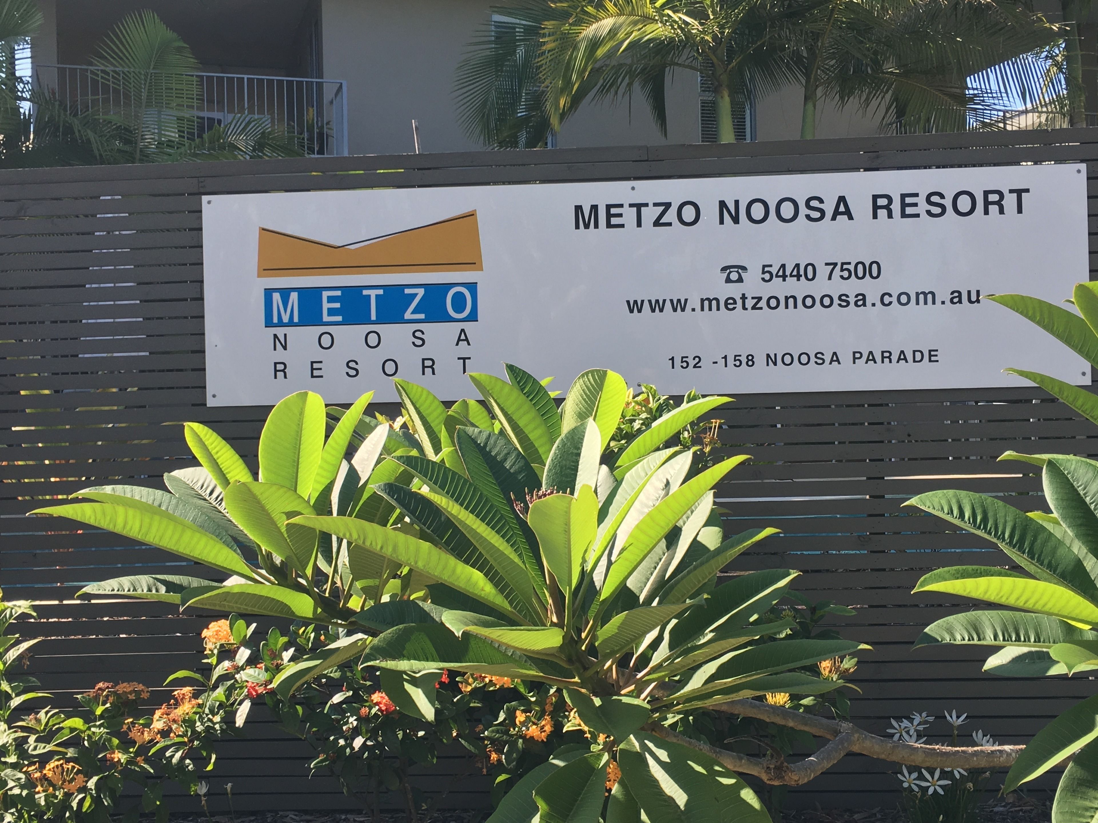 A sign for Metzo Noosa Resort with contact details and address.