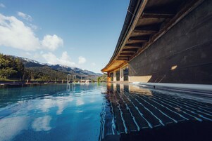 Una piscina al aire libre, sombrillas, sillones reclinables de piscina