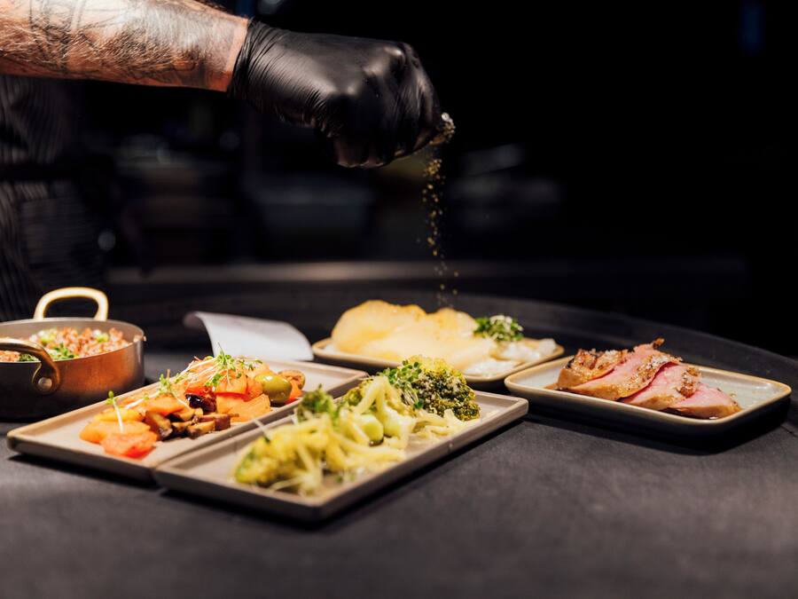 Un chef sazonando comida con una especia.