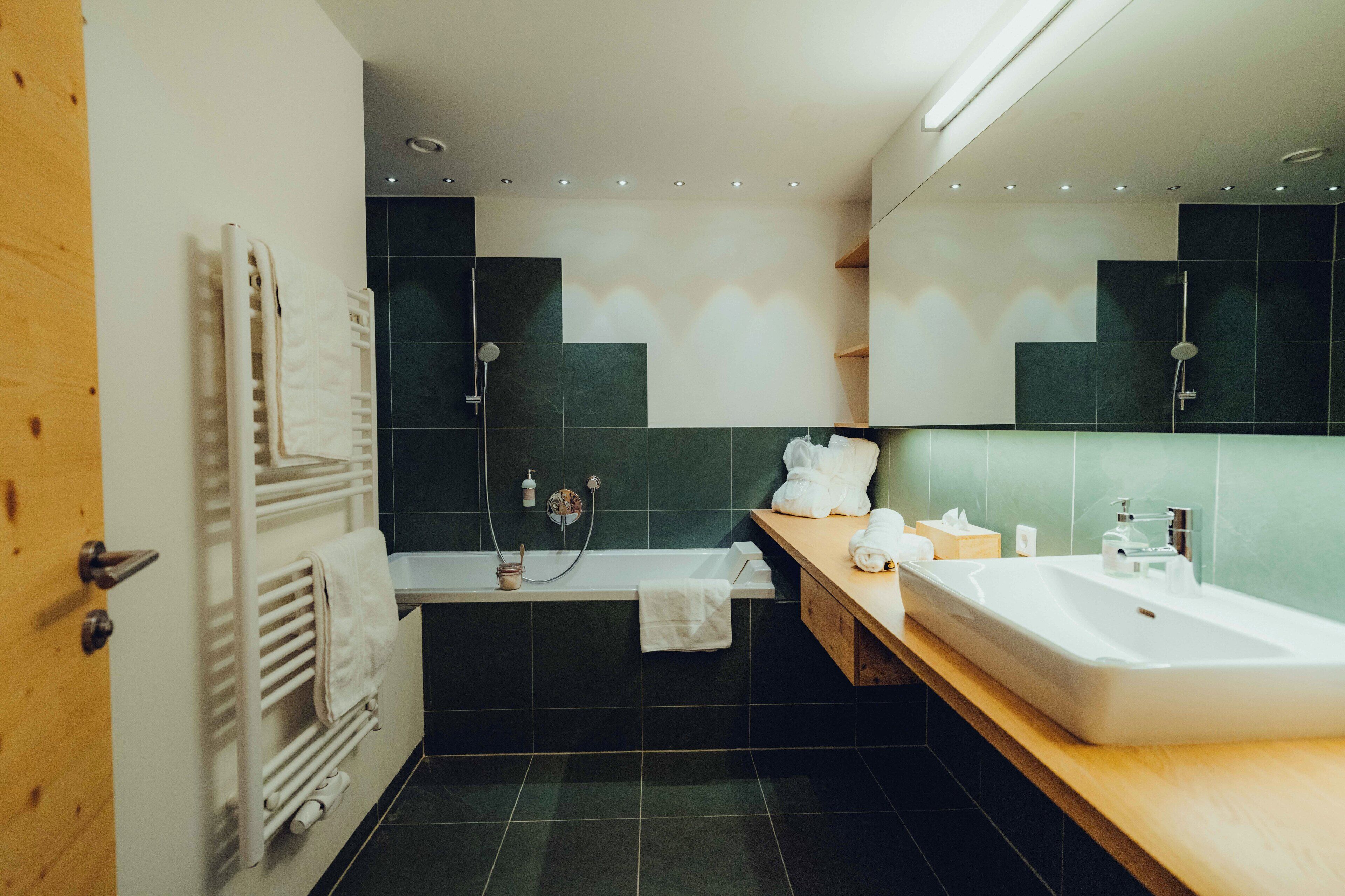 Un baño moderno con bañera, lavamanos y espejo.