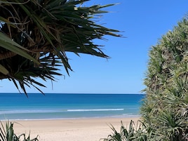 Sable blanc, parasols, serviettes de plage, surf