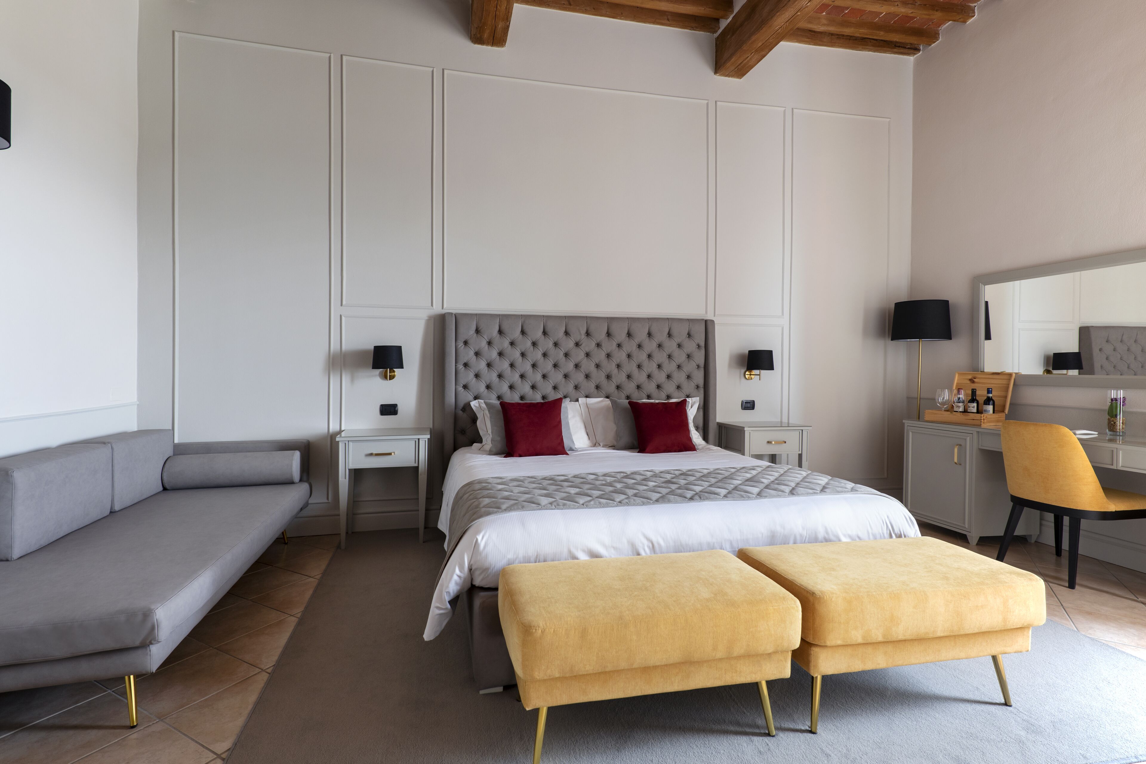 A modern bedroom with a large bed, a sofa, a desk, and a chair.