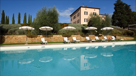 Una piscina al aire libre, sillones reclinables de piscina