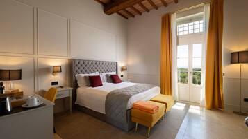 Una habitación de hotel con cama, mesitas de noche, escritorio y vistas por la ventana.