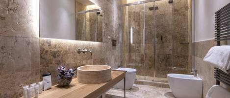 Un baño moderno con tocador de madera, un espejo grande, una bañera independiente y una zona de ducha con mampara de cristal.