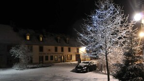 Un patio cubierto de nieve con un coche aparcado y un edificio que dice "HOTEL LA PROVINCENCE".