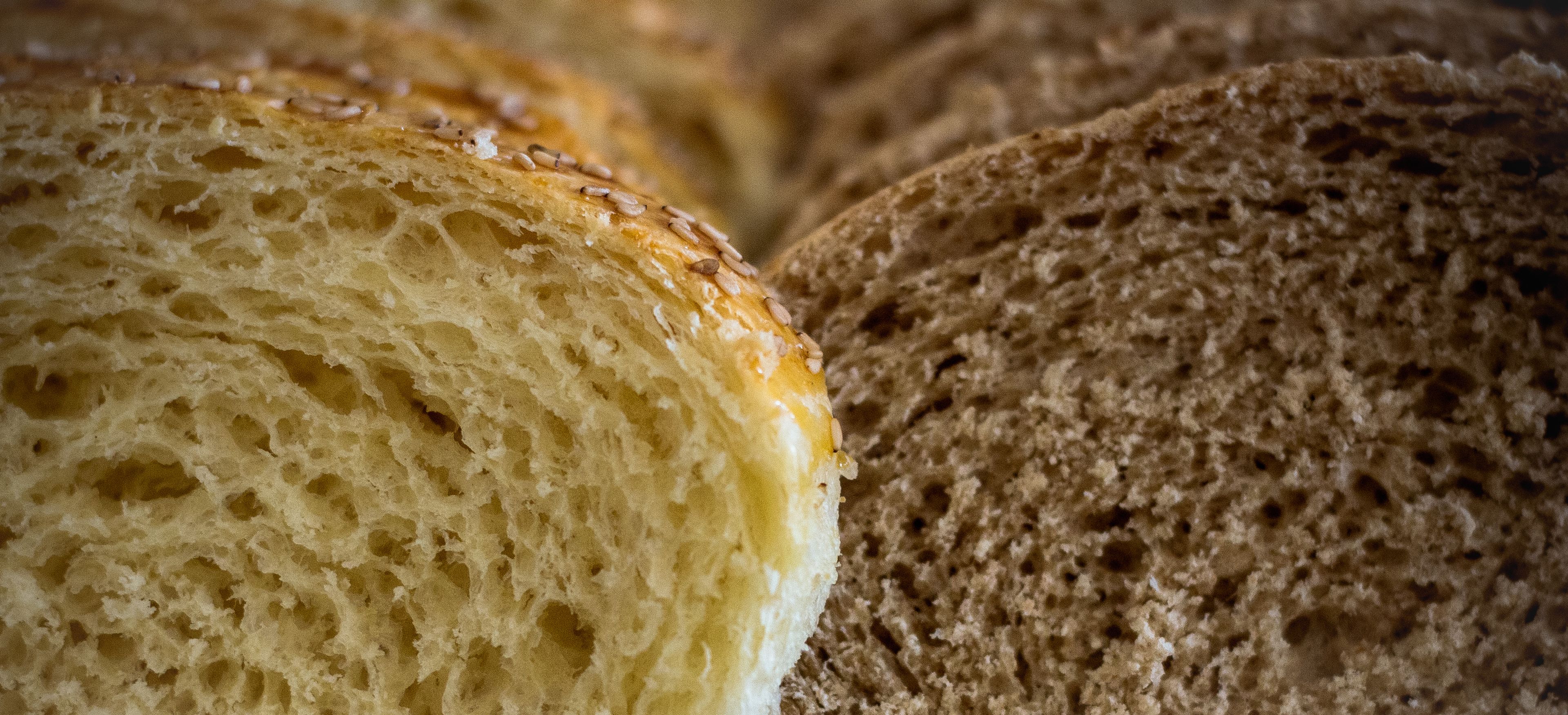A close-up of two loaves of bread, one with a golden crust and the other with a darker crust.