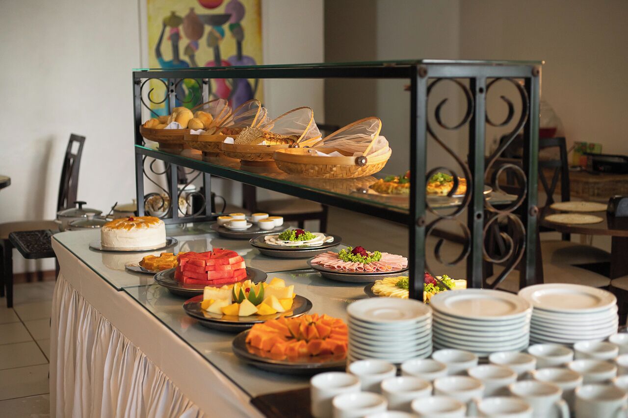 A buffet with various dishes and a cake on a glass table.