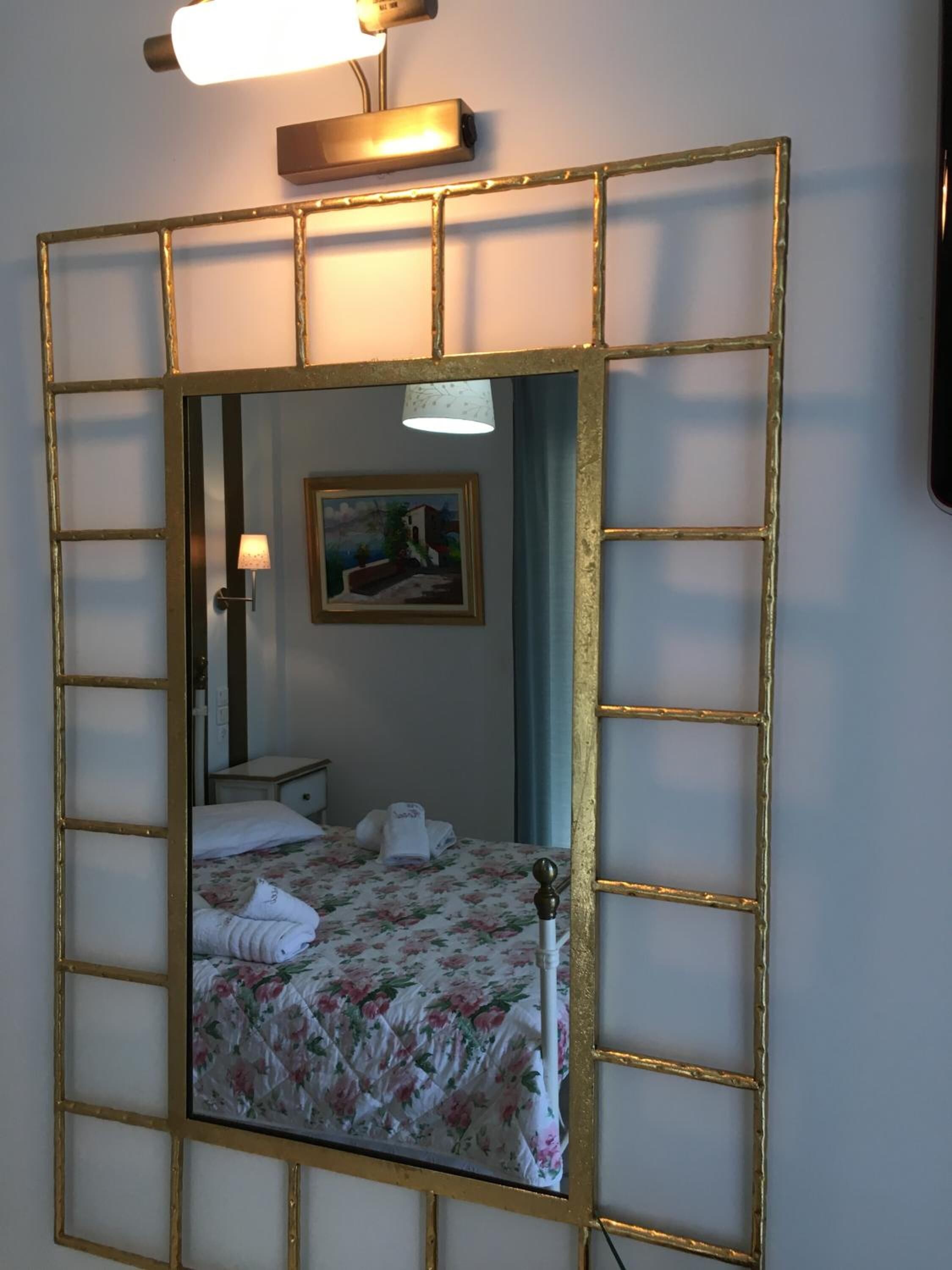A room with a bed, a nightstand, a lamp, and a painting on the wall.