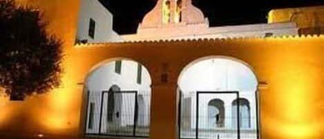 A building with a traditional architectural style, featuring arched doorways and a central tower.