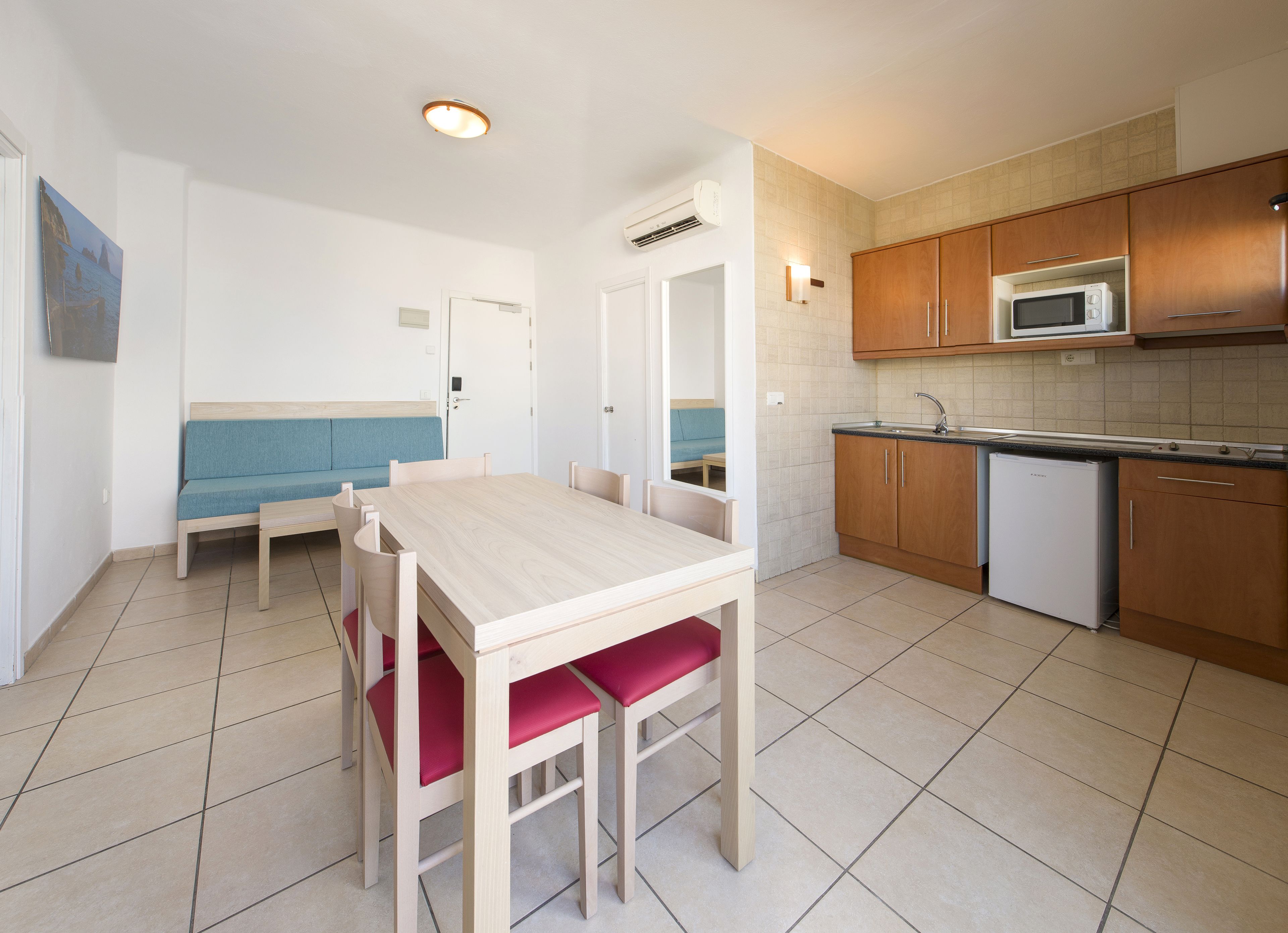 A compact kitchen with a dining table, a microwave, and a refrigerator.