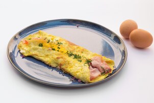 Un plato con una tortilla y dos huevos sobre un plato de cerámica.