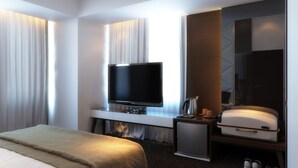 A hotel room with a bed, a TV, a small fridge, a suitcase, and a mirror. - Pandanaran Hotel Semarang (Semarang)
