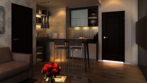 A modern kitchen with a bar area, a dining table with chairs, and a sofa in a living area. - Pandanaran Hotel Semarang (Semarang)