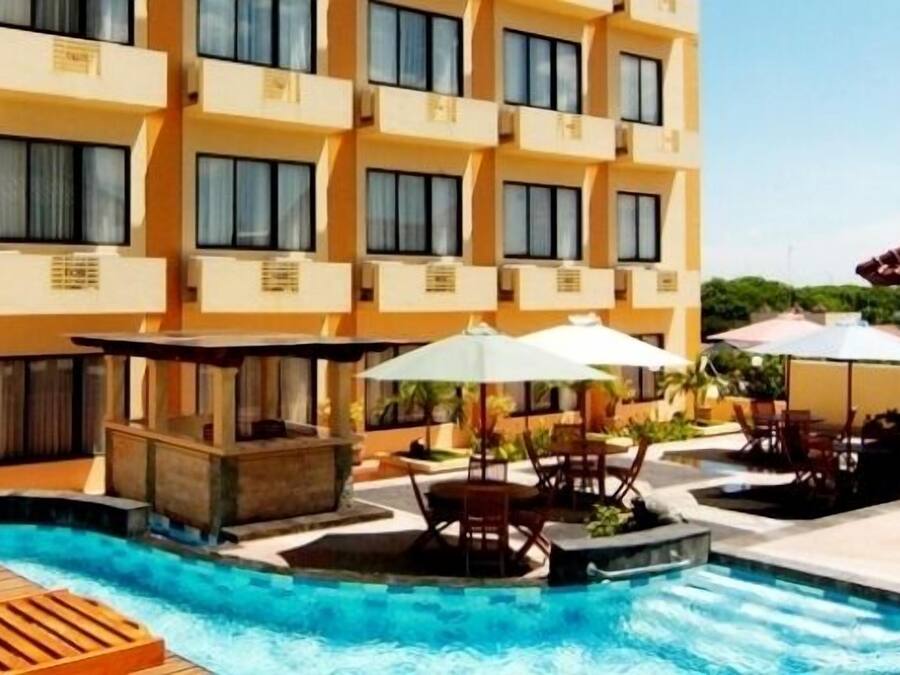 Una piscina al aire libre, sombrillas, sillones reclinables de piscina