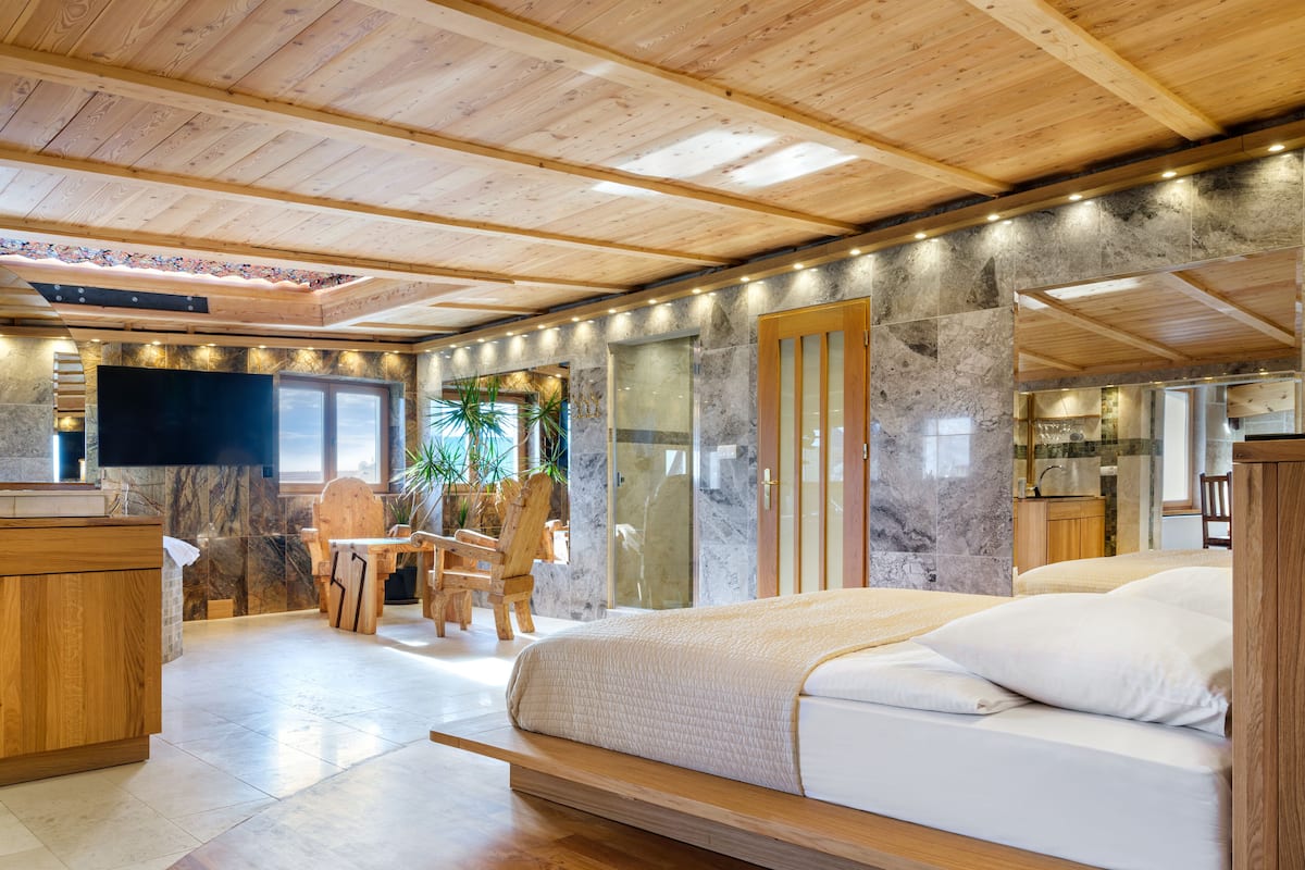 A modern bedroom with a wooden bed, a wooden desk, and a chair.